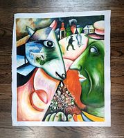 Full view of the signed oil on canvas painting depicting two abstract faces and village scene in the background.