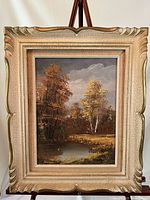 Framed oil painting showing full landscape scene with pond and autumn trees.