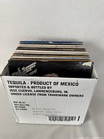 Side view of box containing vintage vinyl records with tequila product branding on box sides.