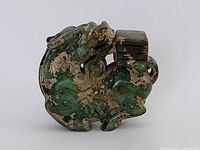 Front view of green stone pendant showing entire carved mythical creature and rectangular bail
