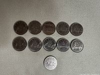 Eleven Canadian silver dollar coins arranged including multiple years and designs.