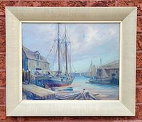 Full view of the oil painting in frame showing several docked sailboats and maritime buildings.