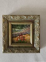 Full view of small framed oil painting by Fay Gee showing detailed garden scene with tulips and stone wall