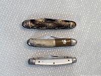 Top view of three vintage pocket cutters showing handles and bolsters