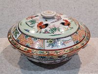 Front angle view of the tureen with lid in place showing rooster and floral designs.