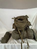 Photo showing the assembled vintage military bag with rolled sleeping bag and tarp in olive drab.