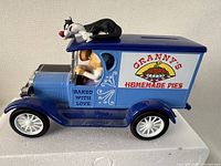 Side view of the blue 1923 Chevy Van piggy bank showing Granny driving and Sylvester on the roof along with 'Granny's Homemade Pies' signage on the side.