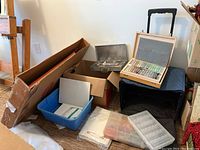 Overall grouping showing wooden pastel box, metal paint case, rolling case, blue bin and other supplies