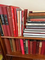 Two-shelf view showing red, green and tan cloth-bound sporting books