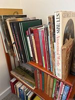 Two wooden shelves filled with horse and hunting themed books, top and bottom rows