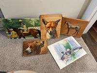 Full view of all five art pieces together showing two canvases, two wooden boards, and one paper piece.