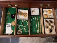 Drawer overview showing all jewelry pieces on green felt lining