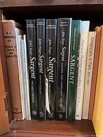 Bookshelf view of brown cloth ‘Pictures of Horses and English Life’, cream spine ‘The Life and Work of Sir Alfred Munnings’, three black Yale University Press John Singer Sargent volumes, green hardcover ‘SARGENT’, white ‘American Painting and Sculpture’ and beige ‘Americans in Paris 1860–1900’.