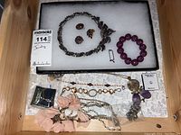 Overview of various jewelry items including necklaces, bracelets, and earrings laid out on white surface