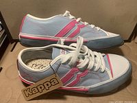 Side and angled view of Kappa leather sneakers showing blue, pink, and white colors and Kappa branded tag attached.
