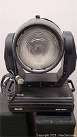 Front view of Martin Mac 600 moving head light showing large lens and base with brand and model markings.
