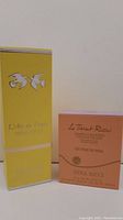 Photo of two boxed items: L'Air du Temps Eau de Toilette in yellow box and Le Teint Ricci eyeliner powder in pink box