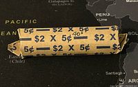 Photo of full roll of 1940s Canadian 5 cent coins wrapped in original $2 x 5¢ paper roll with handwritten '40s' mark, lying on map background.