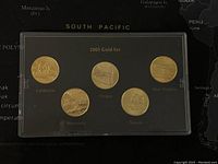 Front side of the coin set showing state designs for California, Oregon, West Virginia, Minnesota, and Kansas with gold layering