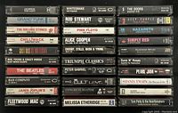 Photo showing a selection of cassette tapes stacked horizontally with artist and album titles visible including Whitesnake, Pink Floyd, Guns N' Roses, Bad Company, The Beatles, and more.