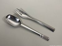 Pair of DANSK silver plated serving utensils, spoon and fork, on neutral background
