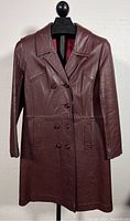 Front view of the burgundy leather trench coat showing full length, collar, and button details.
