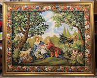 Front view of the large framed Victorian motif needlepoint tapestry depicting a pastoral scene with figures, dog, and floral border.