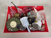 Top view of a box containing various vintage collectible bells, ceramic and glassware items.