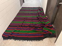 Full view of the wool rug laid out on concrete floor, showing pattern and size