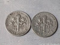 Reverse side of two US dimes showing torch and branches design with clear text "UNITED STATES OF AMERICA" and "ONE DIME".