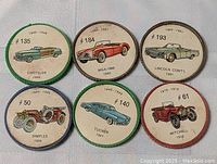 Six vintage cardboard discs with various classic car illustrations and production years from early 1900s to 1961.