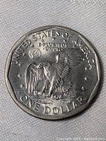 Photo showing the reverse side of the 1979 USA Betsie Ross One Dollar coin with eagle design and inscriptions.