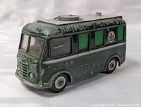 Green die cast Roving Eye toy truck with visible paint wear and side windows, showing front and side.