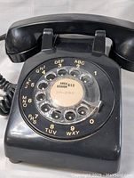 Close-up of rotary dial with area 613 label showing the condition and dial letters/numbers.