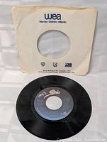 Michael Jackson Billie Jean 45 RPM vinyl record removed from paper sleeve, showing black vinyl with blue and black Epic label marked '1942' in white pen.
