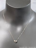 Sterling silver necklace worn on a display bust with a heart-shaped pendant hanging at center front.