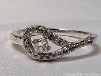 Close-up photo of the sterling silver ring with a central round clear crystal and surrounding smaller crystals on a polished silver band.