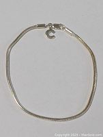 Full view of the sterling silver designer bracelet laid flat showing the entire length and clasp.