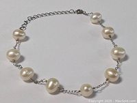 Sterling silver pearl bracelet shown flat on white background, highlighting the spacing and size of pearls along the chain.