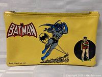 Front view of yellow vinyl vintage Batman pencil case showing Batman, the logo, and Robin graphics.