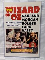 Full view of The Wizard of Oz movie poster showing title, cast text, and character portraits.
