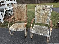 Two vintage white cantilever metal lawn chairs showing front view, perforated metal mesh seat and back, visible rust and wear.