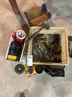 Photo of the overall collection of tools and hardware including hammer, wrenches, screwdrivers, flashlight, grinding disc, and other parts.