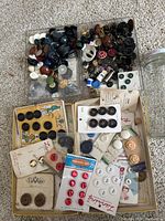 Full view of button collection showing loose buttons in trays and buttons on original cards in box