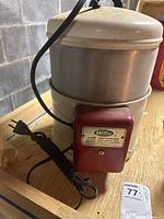 Side view of vintage Home Health pasteurizer showing the metal heating container, lid, and attached power cord.
