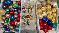 Full view of boxed vintage assorted glass ornaments in three boxes: large colorful balls in shiny metallic finish, some glittered and painted, plus indented vintage bulb shapes with stripes and color blocks.