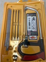 Top view of the 7 piece mini multi purpose saw set in yellow packaging illustrating the saw handle, large metal blade, and five smaller blades.