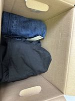 Blue denim and black fabric clothing folded in a box