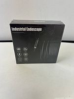 Front of the sealed box showing the product name 'Industrial Endoscope' and feature icons.