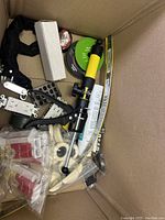 Top view showing various items including a yellow and black fishing rod or pole component and mechanical parts